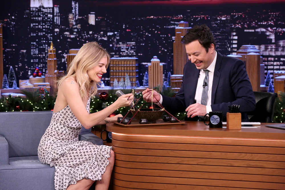 THE TONIGHT SHOW STARRING JIMMY FALLON -- Episode 0592 -- Pictured: (l-r) Actress Sienna Miller and host Jimmy Fallon take part in "The Ramen Challenge" on December 15, 2016 -- (Photo by: Andrew Lipovsky/NBC)